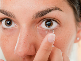 woman putting on contacts